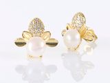 a pair of pearl and diamond earrings on a white surface