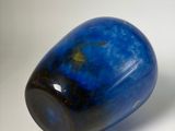 a blue stone that is sitting on a white surface
