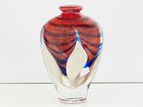 a glass vase with a red and blue design on it