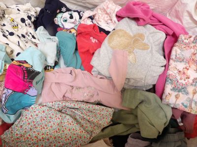 une pile de vêtements posée sur un lit