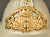 a white helmet with a gold emblem on it