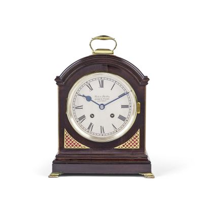 une petite horloge en bois avec des chiffres romains sur le cadran