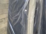 de nombreux matelas emballés dans du plastique, posés par terre