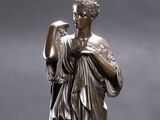 bronze statue of a woman holding a bird on a pedestal