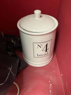un récipient blanc sur lequel figure un numéro, à côté d'un sac à main