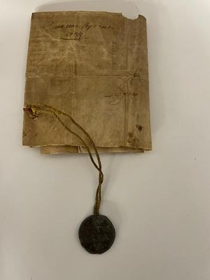 un vieux bout de papier sur lequel est apposé un cachet de cire