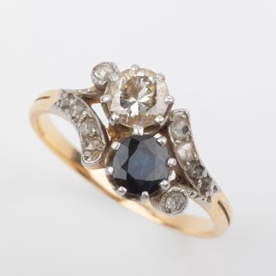 a close up of a diamond and sapphire ring on a white background