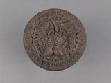 un vieux bouton en bronze orné d'un oiseau