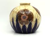 a blue and yellow vase with a flower on it