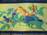 un tapis sur lequel sont représentés deux oiseaux, posé sur un parquet