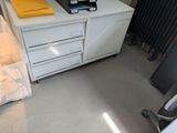 a white dresser with a yellow shirt on top of it