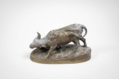 bronze statue of a bull running on a rock on a white background