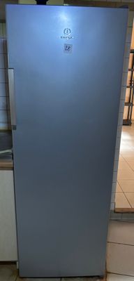 a blue refrigerator in a kitchen with tile flooring