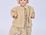 a small doll that is wearing a dress and hat
