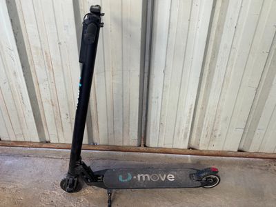un scooter posé sur le sol à côté d'un mur