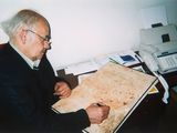 a man that is sitting at a desk writing on a piece of paper