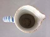 a blue and white vase with a blue stripe on it