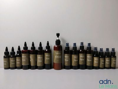 plusieurs flacons de différents types de produits de soin pour la peau alignés sur une surface blanche