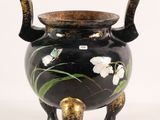 a black and gold vase with flowers on it