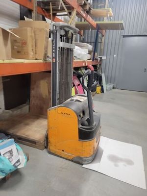 a forklift in a warehouse with boxes on the floor