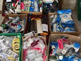 plusieurs cartons contenant des objets divers, posés par terre devant un mur