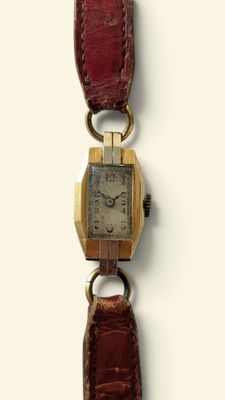 une image d'un gros plan d'une montre-bracelet sur une surface blanche