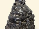 une petite statue représentant un homme assis sur un tabouret