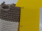 a crochet bag next to a ruler on a table