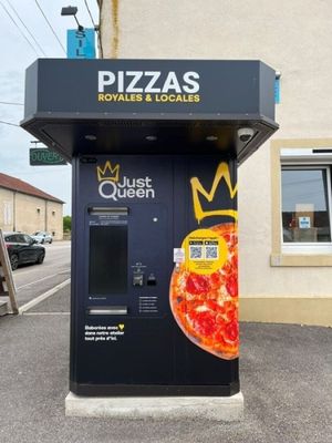 un distributeur automatique de pizzas installé contre un immeuble