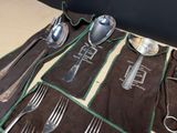 a set of silverware on a table with a black cloth