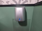 des toilettes avec un distributeur de papier dans un coin de la salle de bains