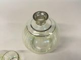 a small glass jar with a ring on top of it