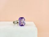 an amethorate ring with a purple stone on top of a white block