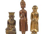 trois statues de Bouddha en bois et un Bouddha assis sur un rocher