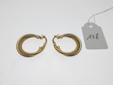 une paire de boucles d'oreilles créoles en or avec une étiquette de prix
