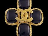 un gros plan sur une broche Chanel noire et dorée