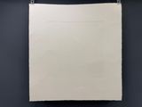 une feuille de papier blanche accrochée à un mur noir