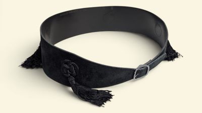 a black belt with tassels on it on a white surface