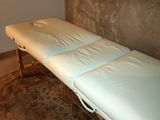 une photo d'une table de massage dans un coin d'une pièce