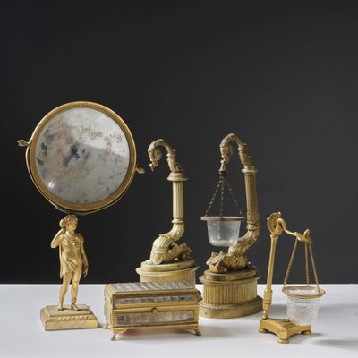 une table sur laquelle se trouvent une horloge, une balance et d'autres objets