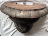 un bol en bois posé sur une table, surmonté d'un anneau