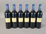 six bottles of wine are lined up in a row
