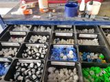 many different types of screws in the bins on the table