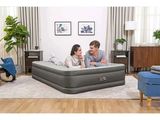 an image of a man and woman sitting on an air mattress in a living room