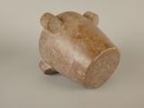 a small brown bear figurine sitting on a white surface