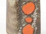 a small vase with two orange hearts on it