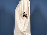 a white shirt on a mannequin stand against a blue wall
