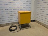 a yellow box sitting on a metal stand in front of a wall