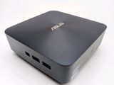 the asus mini pc is sitting on a white surface