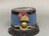 un petit chapeau bleu orné d'un emblème doré